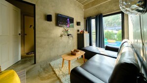 A living room with a TV, sofa, and a small table.