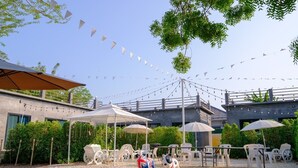 An outdoor seating area with umbrellas, chairs, and a decorative dog statue.