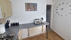 Eine Küche mit Heizkörper, Toaster und Wanduhr.