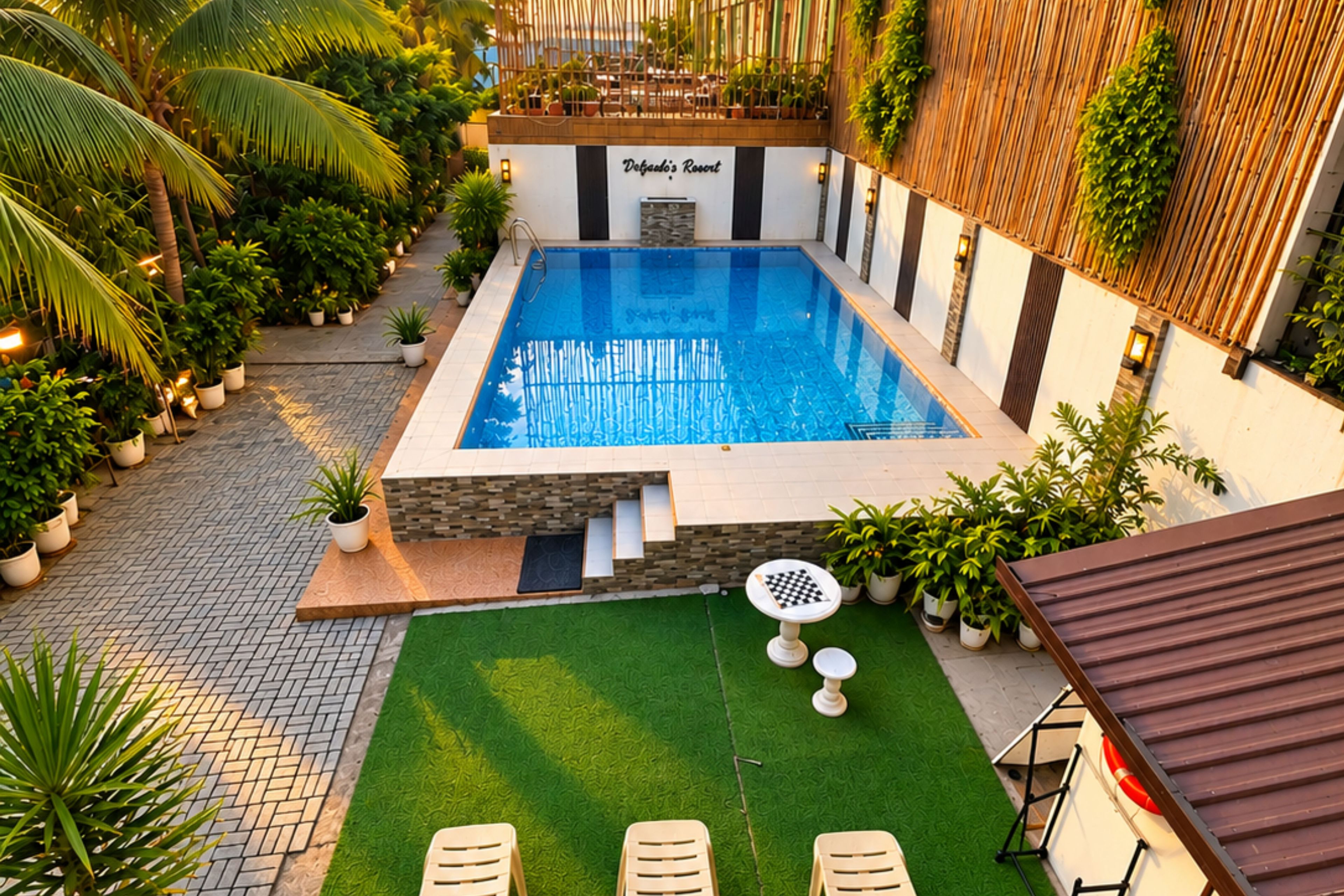 Une piscine dotée d’une terrasse en bois et d’un petit jardin agrémenté d’une table d’échecs.