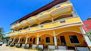 A multi-story yellow building with balconies and a flat roof. - Delgados Resort Puerto Galera powered by Cocotel (Puerto Galera)