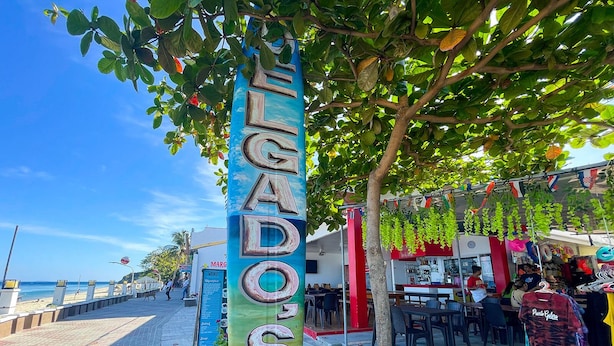 A sign for 'El Gado's Resort' with a view of the beach and a restaurant in the background. - Delgados Resort Puerto Galera powered by Cocotel (Puerto Galera)