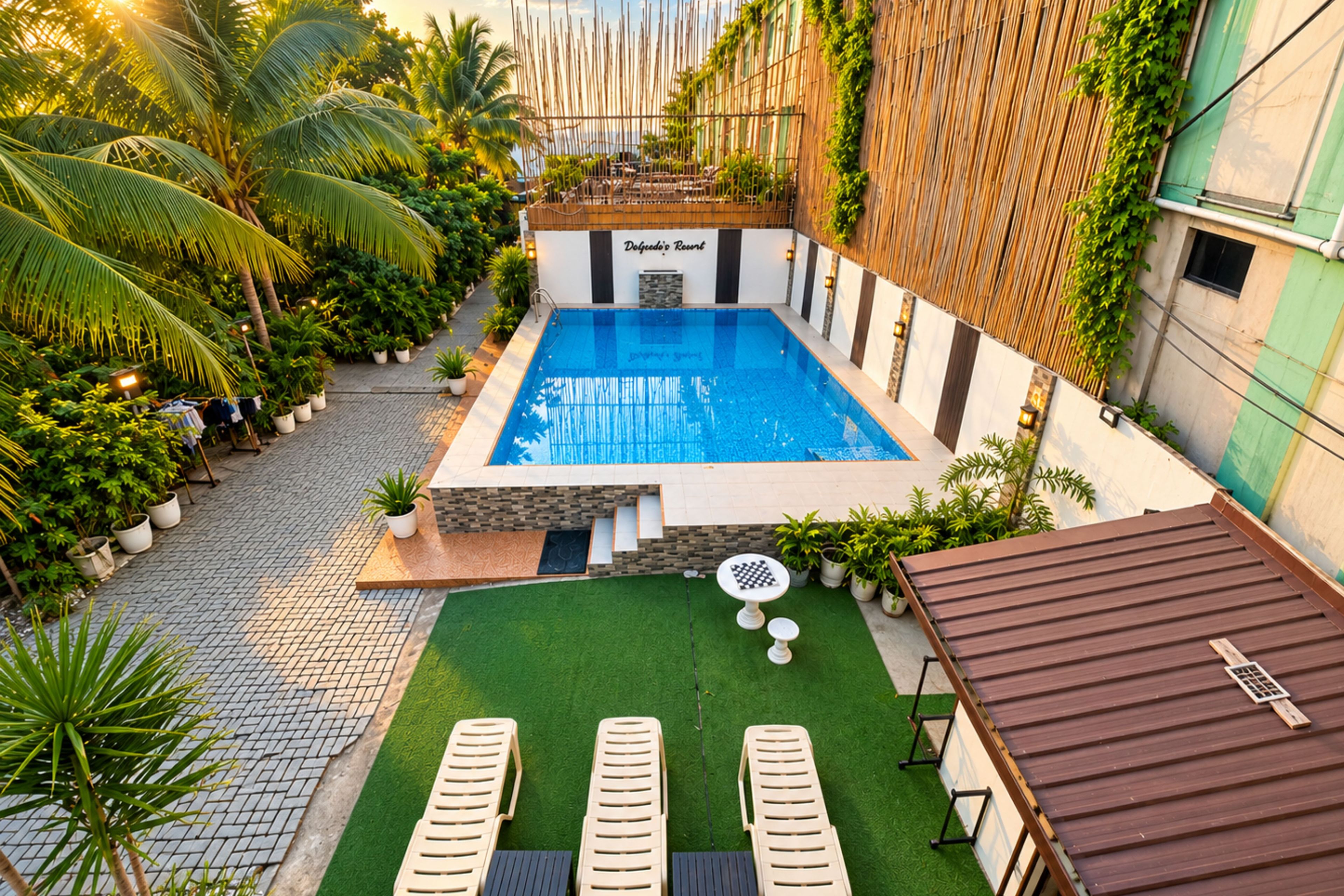 A rooftop swimming pool with a view of the city, surrounded by greenery and potted plants.