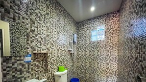A bathroom with a mosaic tile wall, a white sink, a toilet, and a shower area. - Delgados Resort Puerto Galera powered by Cocotel (Puerto Galera)