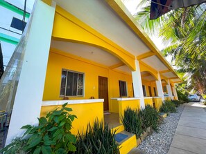 A yellow building with a covered porch, windows, and a door. - Delgados Resort Puerto Galera powered by Cocotel (Puerto Galera)