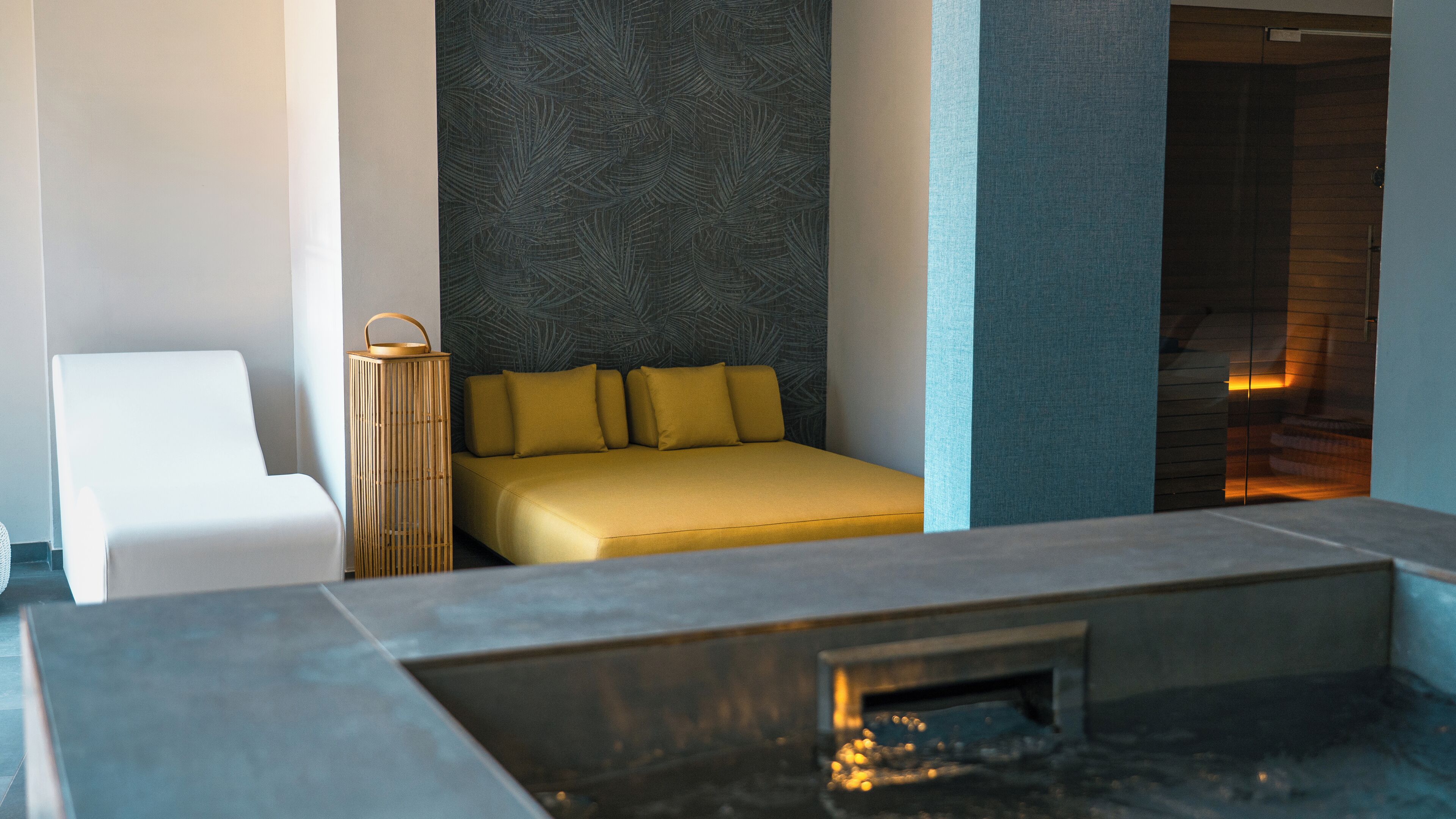 Una habitación de hotel moderna con cama, sofá, una mesita y bañera.