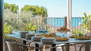 A dining table set for a meal with plates, glasses, and bottles, overlooking a scenic view. - AHG Riva Del Sole Wellness Hotel - Adults Only (Moniga del Garda)