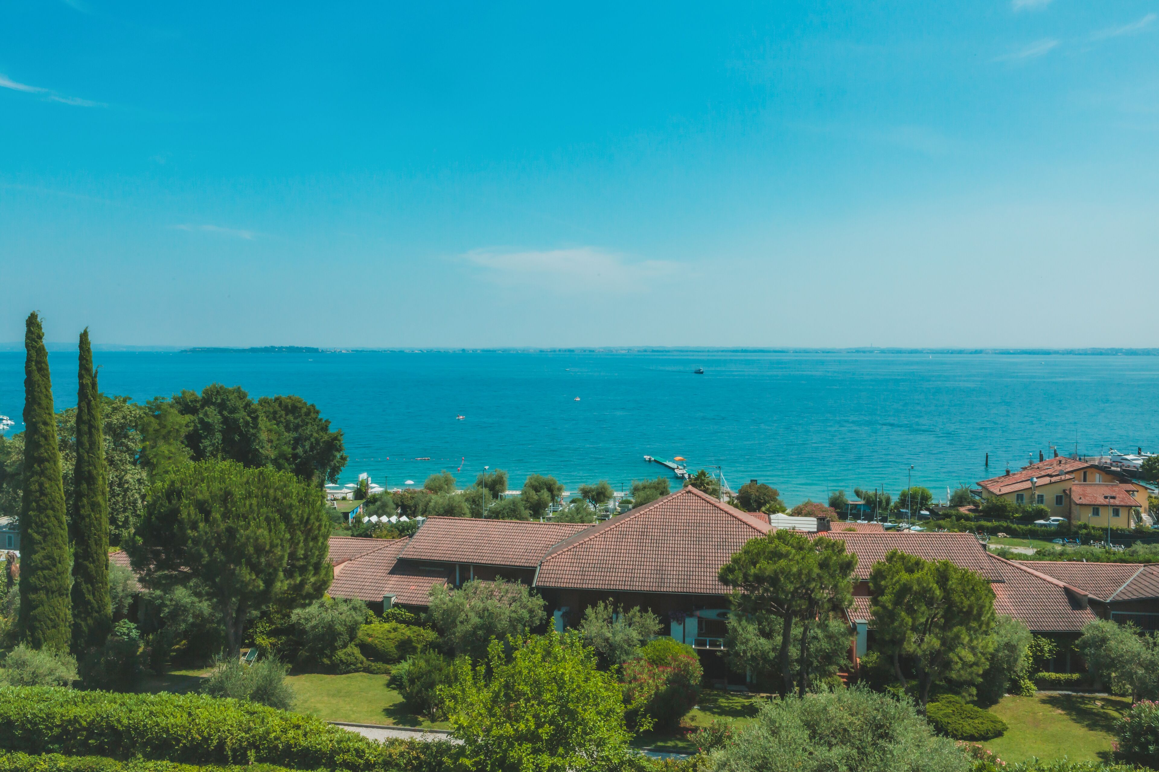 Un área residencial costera con casas, un mar azul cristalino y una costa distante.