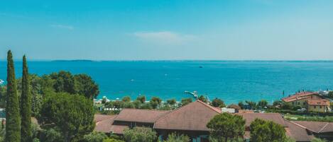 Un área residencial costera con casas, un mar azul cristalino y una costa distante.