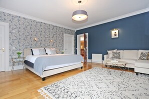 A bedroom with a bed, bedside table, and a nightstand. There is a door leading to another room. - Luxury Manor Private Cinema, Bar, Games & Music Rooms. Perfect for Large Groups (Limerick)