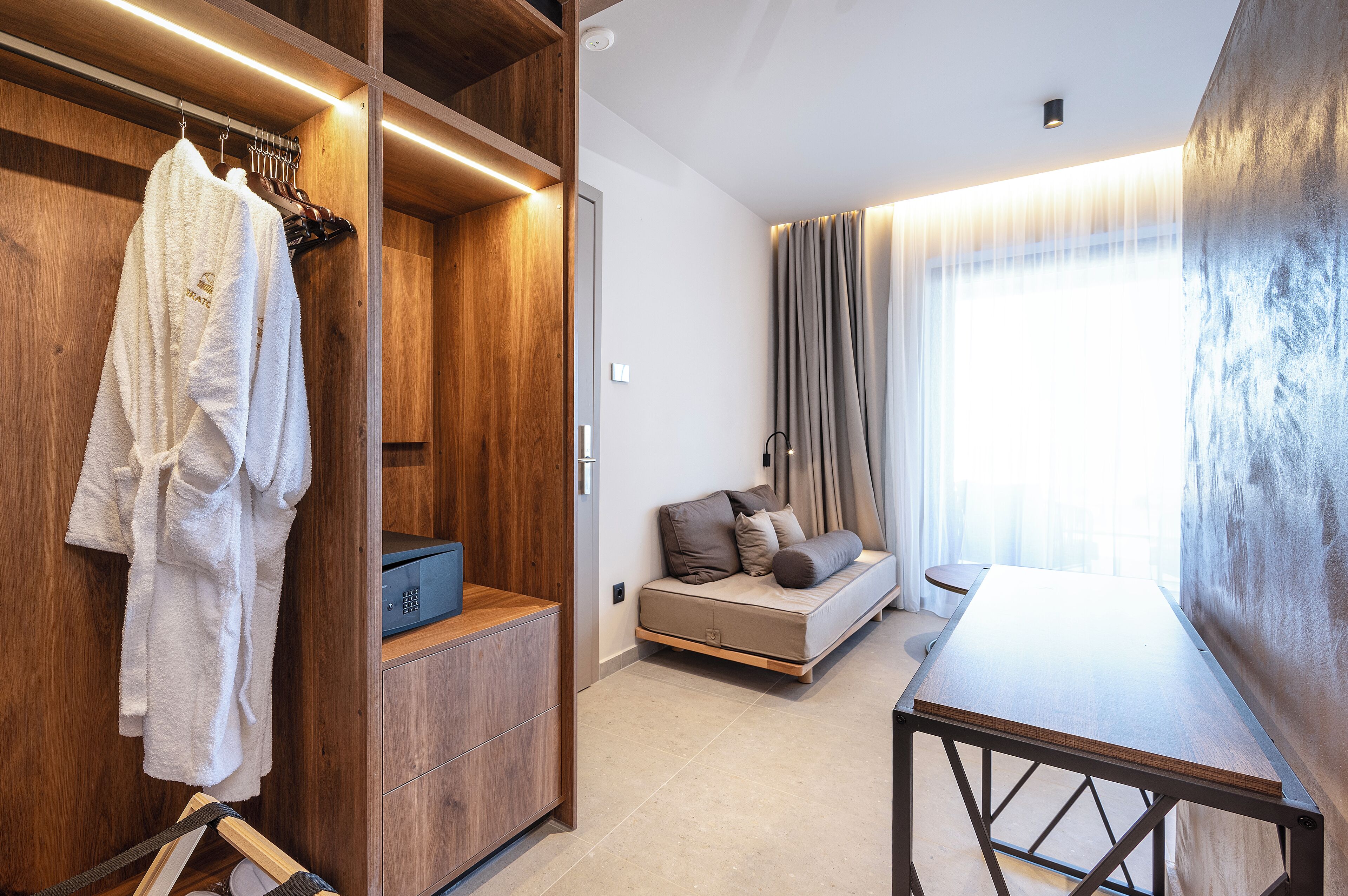 A modern room with a wooden wardrobe, a sofa bed, and a table.