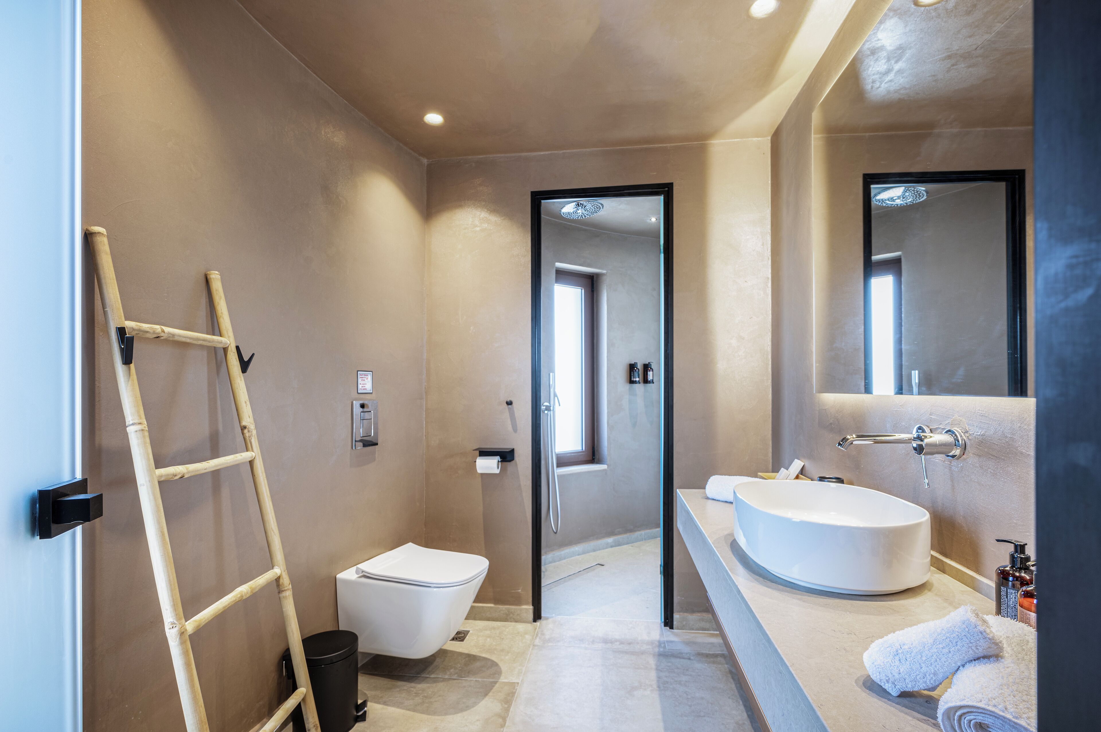 A modern bathroom with a toilet, sink, and mirror.