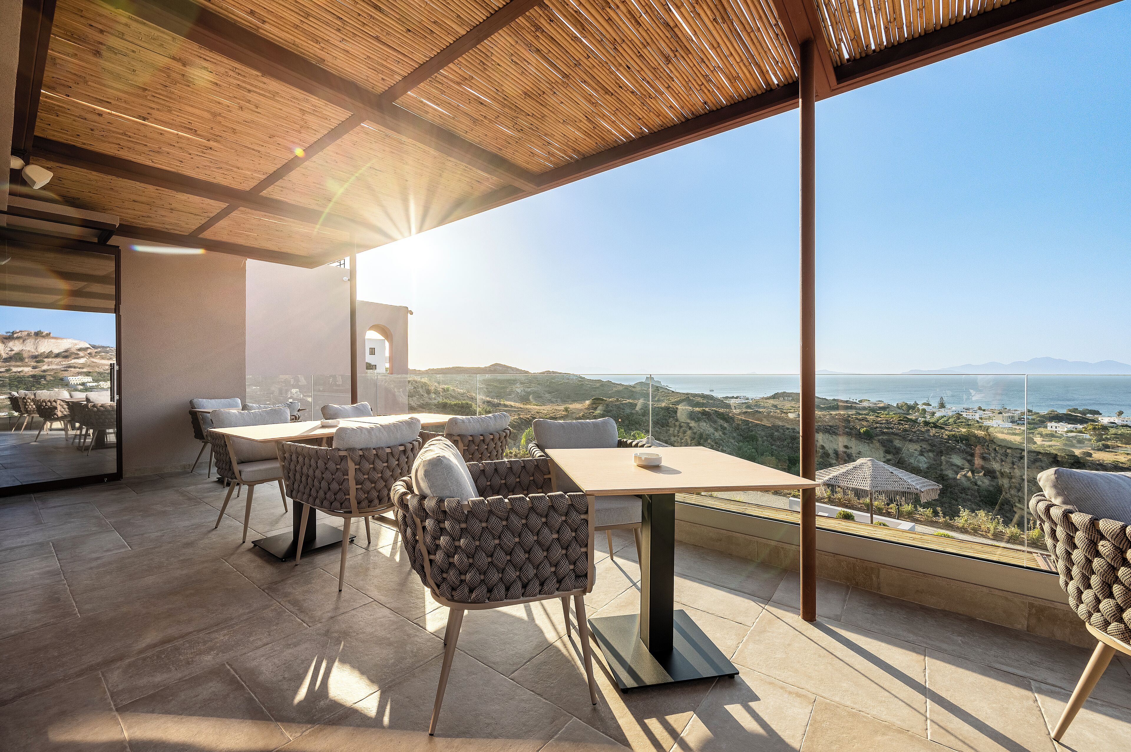 A modern outdoor dining area with a panoramic view of the landscape.