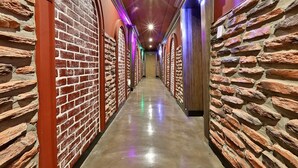 A corridor with brick walls and a polished floor, leading to a door at the end. - Hotel February Gimhae (Gimhae)