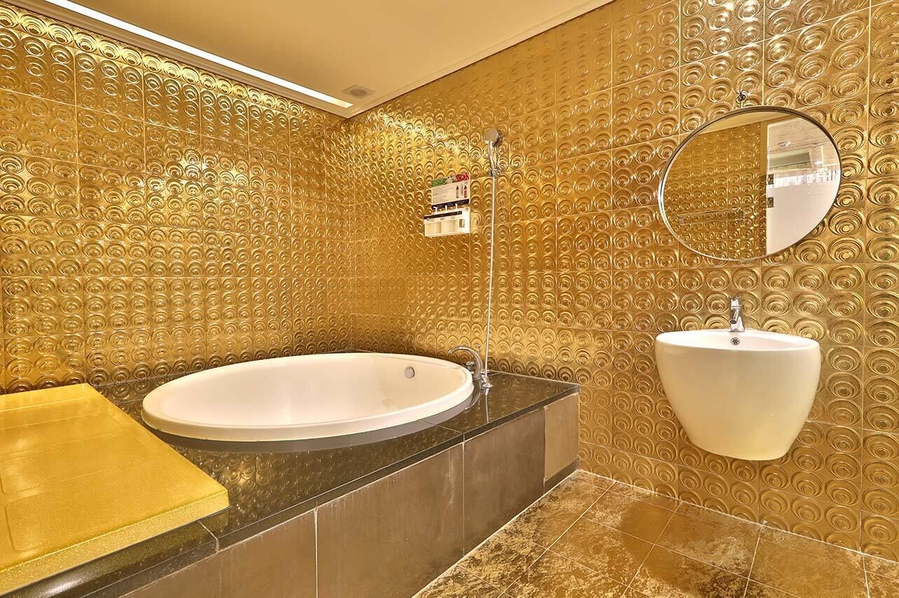 A bathroom with a large bathtub, a sink, and a mirror.