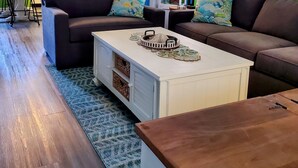 A living room with a brown sofa, a white coffee table, and a patterned rug. - Exquisite 2 Bedroom/2 Bathroom - Walk to Beach and Boardwalk (Ocean City)