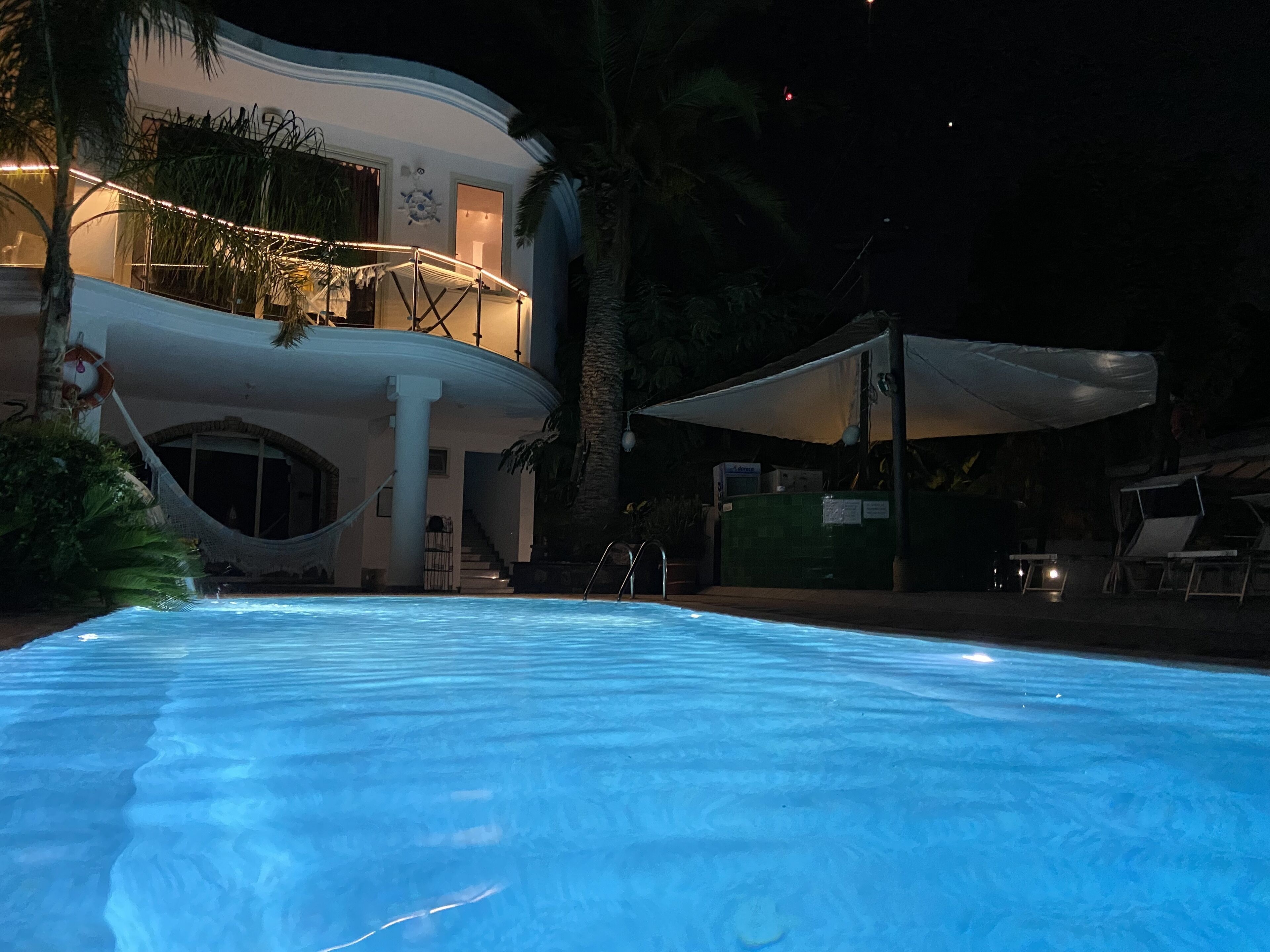 A swimming pool with a white building in the background.