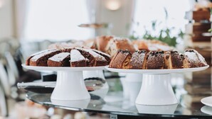 A buffet table with various food items including a cake, fruit, and pastries. - Hotel Gabbiano by Double Hospitality (Garda)
