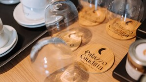 Una mesa de madera cubierta con una cúpula de cristal transparente y posavasos de madera con texto.