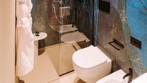 A modern bathroom with a glass shower enclosure, a white toilet, and a sink. - Suite Queen Room 2 maggio (Monopoli)