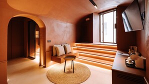 Un interior modern amb una escala, una zona de seients i un televisió de pantalla plana penjada a la paret.