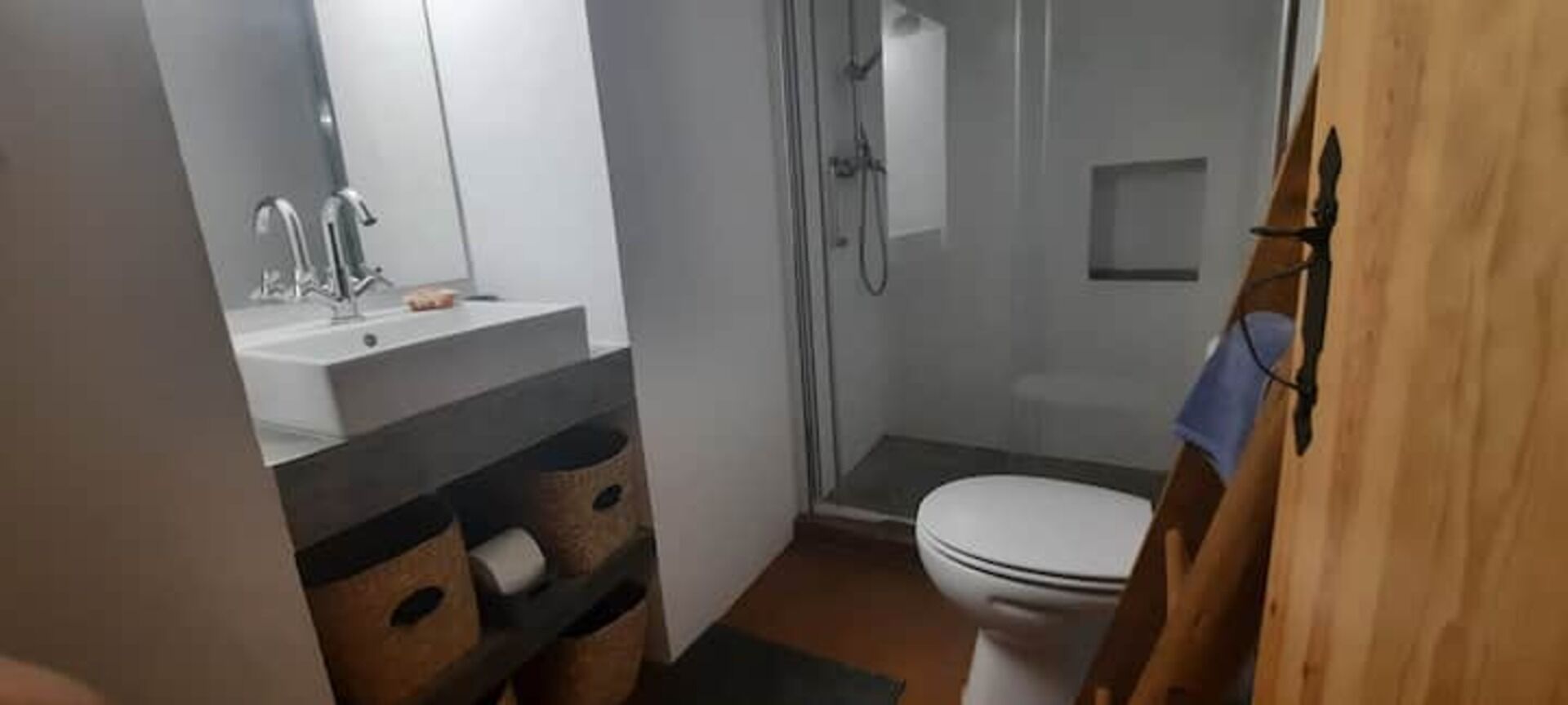 Un baño pequeño con ducha, inodoro y lavamanos.