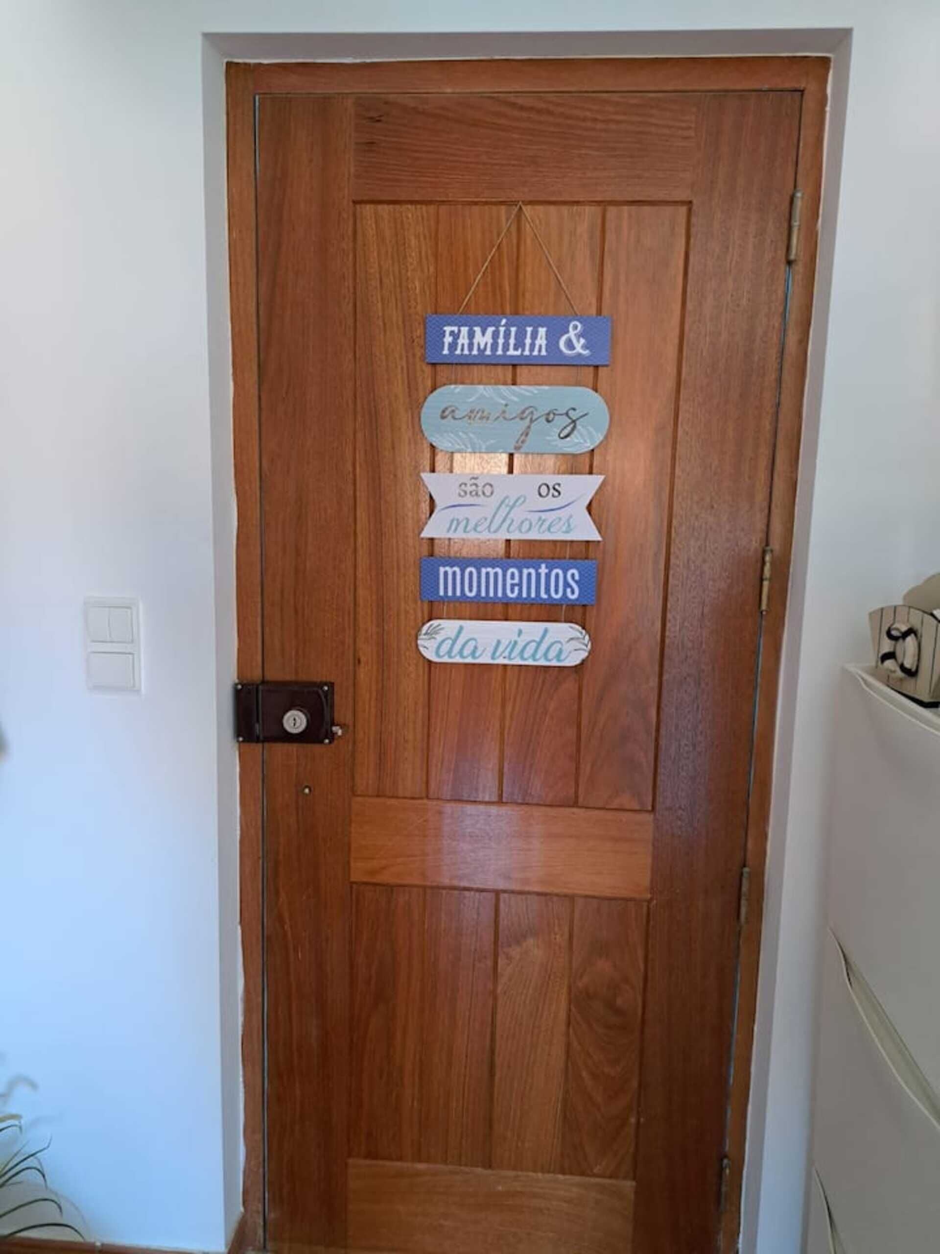 A wooden door with a sign that reads "FAMÍLIA & amigos são os melhores momentos da vida."