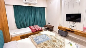 Un dormitorio moderno con cama, televisor, aire acondicionado y ventilador de techo.