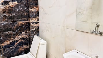 Habitació triple Deluxe | Bany | Dutxa, capçal de dutxa tipus cascada, terres tèrmics i tovalloles