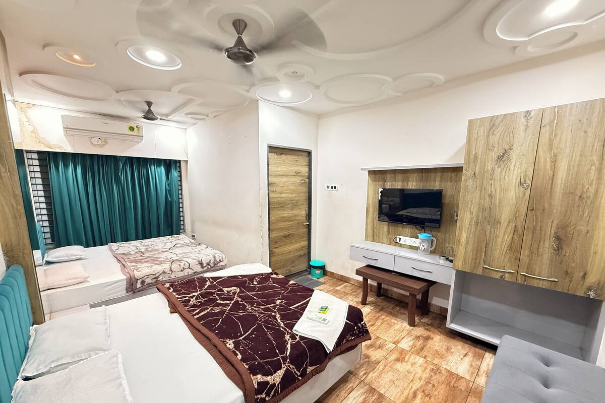 A hotel room with a bed, a desk, a TV, and a wardrobe.