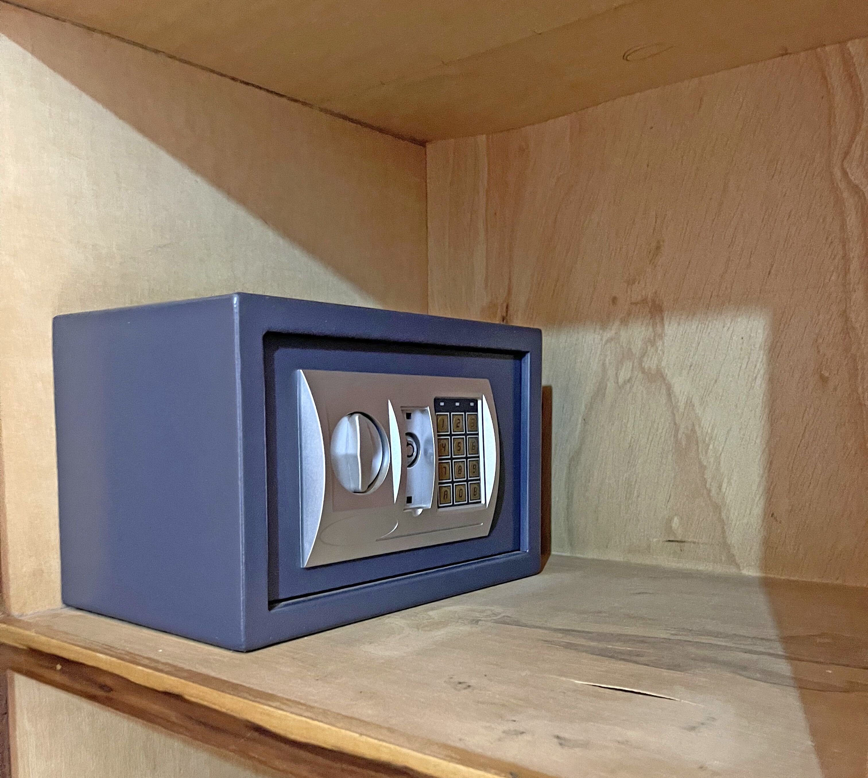 Una caja fuerte azul sobre un estante de madera.