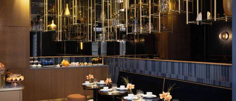 A modern restaurant with round tables, gold fixtures, and a dark interior.