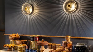 A breakfast buffet with various breads, pastries, and condiments. - Hôtel Filigrane & Spa (Paris)