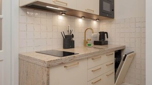 Une cuisine moderne équipée d’un four à micro-ondes encastré, d’une cuisinière à gaz et d’un lave-vaisselle.