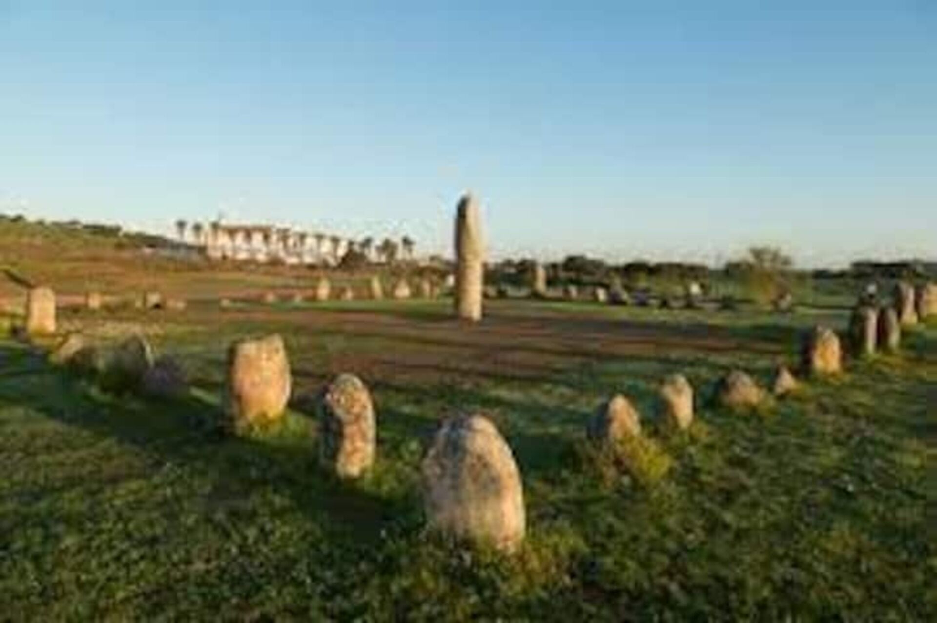 A rural landscape with stone structures and a clear sky.