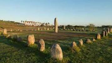 A rural landscape with stone structures and a clear sky.