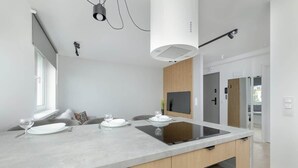 Una cocina moderna con una isla central, horno empotrado y un ventanal grande.