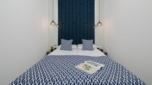 A neatly made bed with a patterned bedspread, a dark headboard, and two bedside lamps.