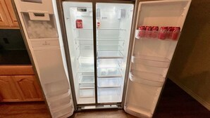 A double-door refrigerator with two door compartments, a freezer compartment, and a shelf for beverages.
