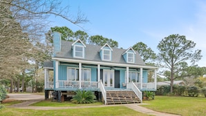 A two-story house with a porch, a chimney, and a well-maintained lawn.