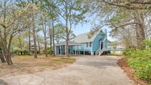 A blue house with a covered porch and a staircase leading to the entrance.