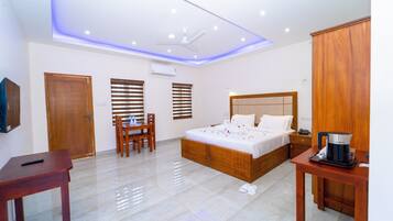 Una habitación de hotel moderna con una cama de madera, un escritorio, una silla y una cafetera.