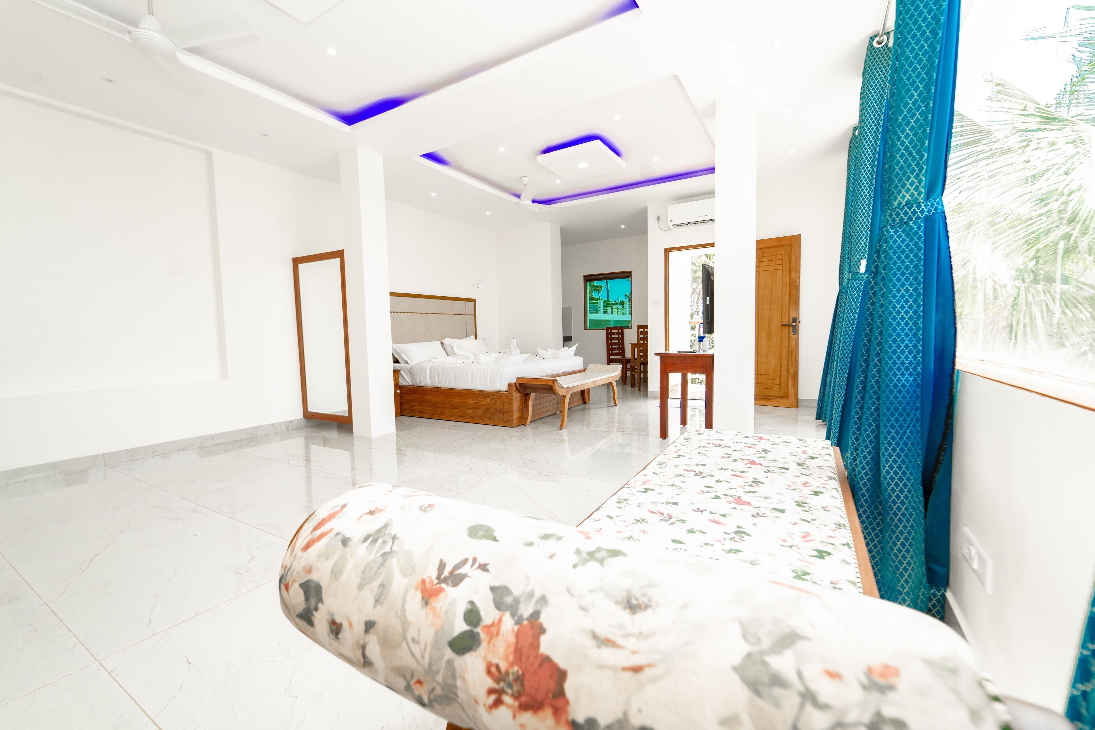 Une chambre d’hôtel moderne, dotée d’un grand lit, d’un canapé, d’une télévision et offrant une vue sur l’extérieur.