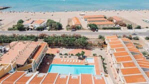 A coastal hotel with a swimming pool, beach view, and multiple buildings with red-tiled roofs. - Club Malaspina Hotel & Resort (Bosa)