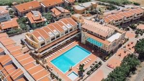 A residential area with a swimming pool surrounded by multiple buildings with red-tiled roofs. - Club Malaspina Hotel & Resort (Bosa)
