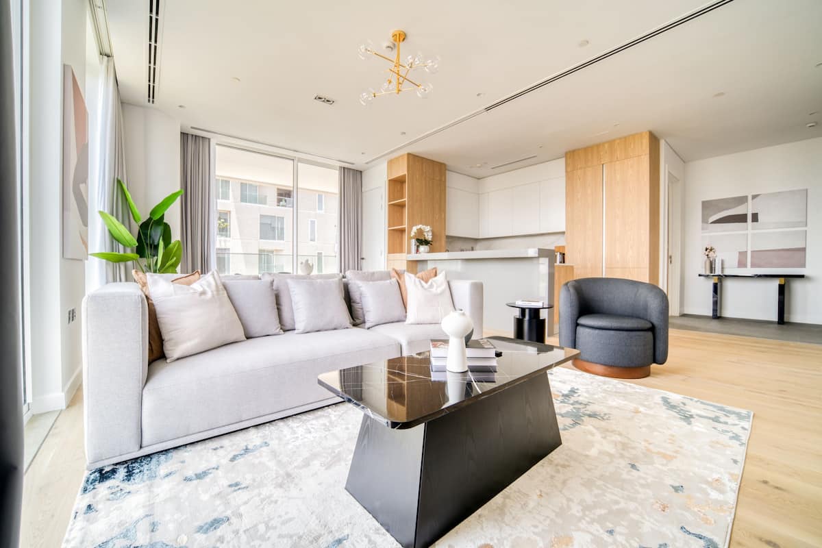 Una sala moderna con un sofá modular, una mesa de centro y un sillón gris.