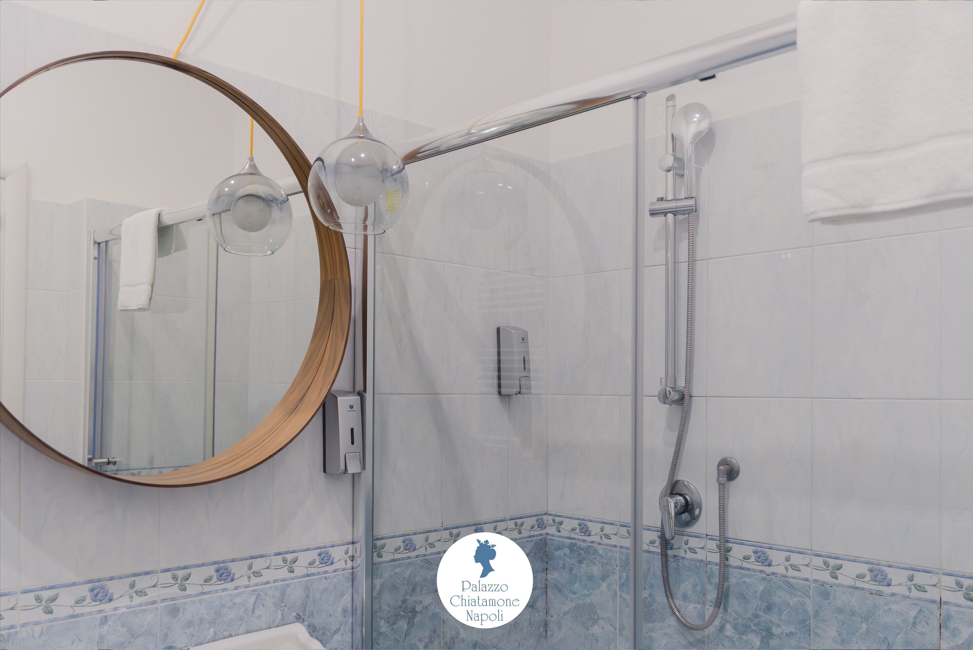 A bathroom with a shower, a towel rack, and a mirror.