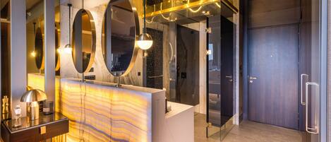 A modern reception area with a marble counter, large mirrors, and contemporary lighting fixtures.