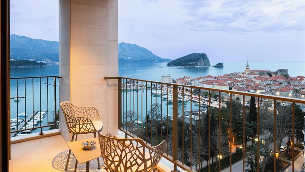 A balcony with a view of a marina and a town. - Merit Starlit Hotel Casino & SPA (Budva)