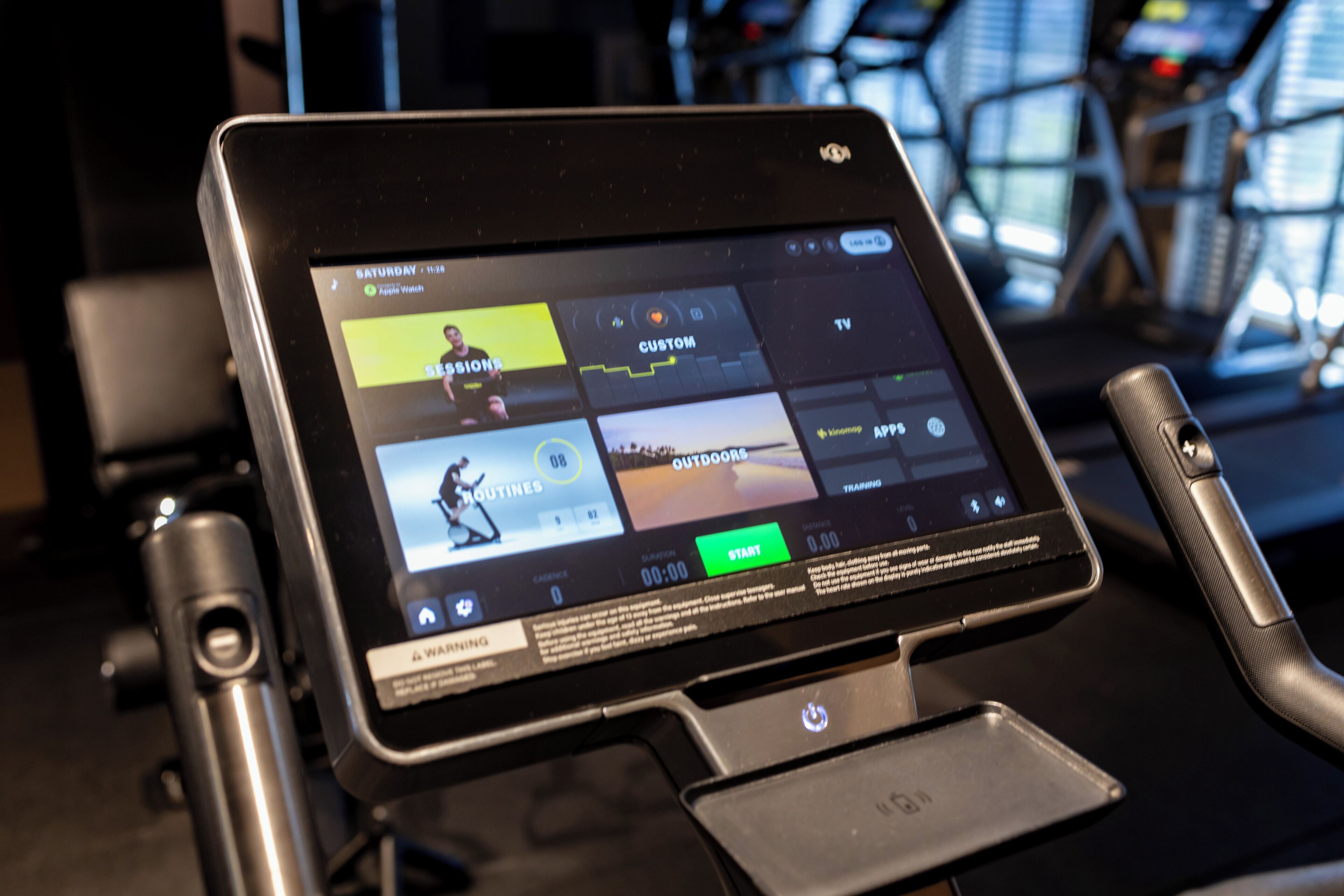 A digital display on a stationary bike showing workout options.